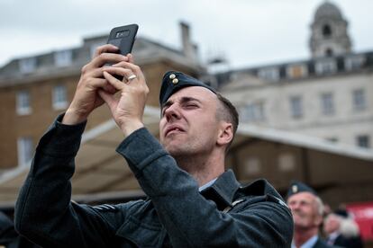 Un miembro de la Royal Air Force fotografía con su móvil el desfile aéreo por el centenario de la organización en Londres (Reino Unido).