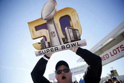 Un fanático carga una insignia del SuperBowl edición 50.