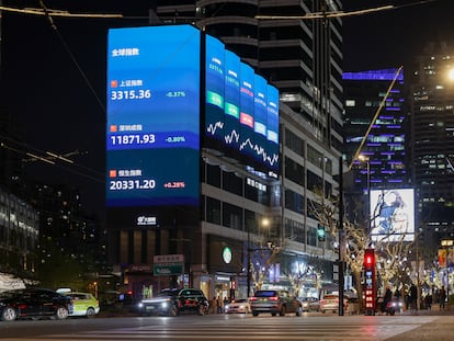 Imagen de una calle de Shanghai en la que se aprecia en una pantalla la evolución de los índices chinos.