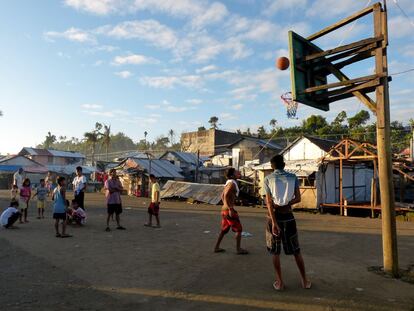 Un grupo de niños y jóvenes juega al baloncesto en Tacloban (Filipinas) en una zona que quedó inundada tras el paso del tifón Haiyán.