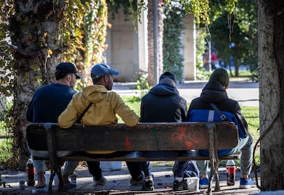 Un grupo de inmigrantes en el Jardín del Turia de Valencia durante un reparto de comida.