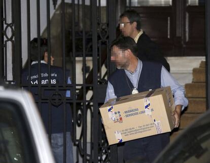 Funcionarios de la Agencia Tributaria (AEAT), Agentes del Servicio de Vigilancia Aduanera (SVA) y miembros del Cuerpo Nacional de Policía sacan cajas con documentación del despacho del exvicepresidente del Gobierno. Efe