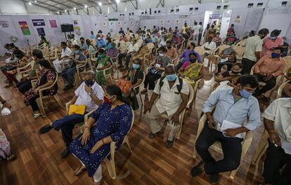 Un grupo de ciudadanos de Bombay espera los efectos de la vacuna contra el coronavirus este viernes en un centro de vacunación.