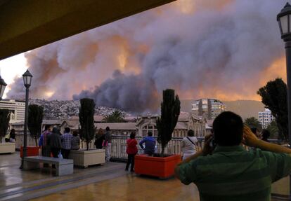 Pessoas observam as nuvens de fumaça do incêndio florestal na cidade de Valparaíso, ao noroeste de Santiago.