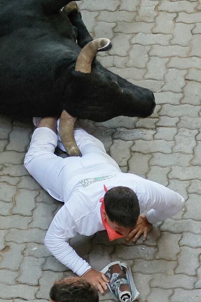 Un morlaco cae encima de un corredor a su llegada al callejón.