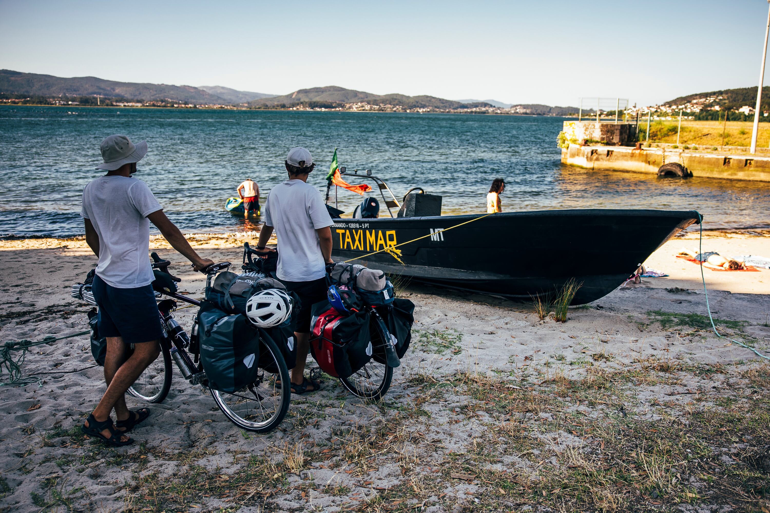 Dos peregrinos franceses aguardan la salida de una barca para cruzar la desembocadura del río Miño con sus bicicletas, desde Caminha (Portugal) hasta A Guarda (Pontevedra).