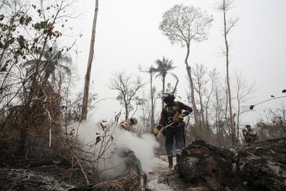 Bomberos trabajan en el enfriamiento del terreno tras un incendio forestal en Río Blanco, Bolivia, 12 de septiembre de 2024. 