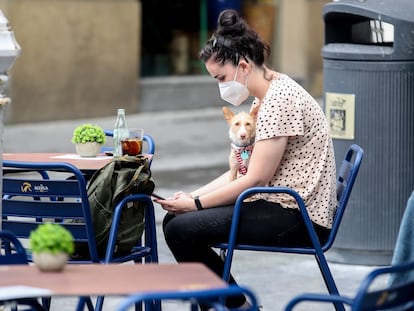 Una joven toma una consumición protegida con mascarilla en una terraza de San Sebastián.