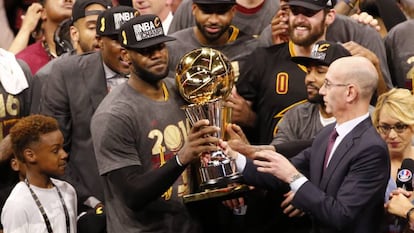 Silver le entrega la copa de campeón a LeBron.