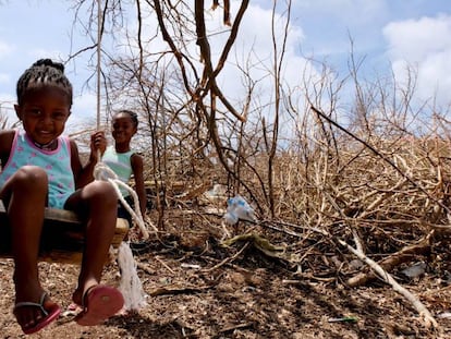 Tiquania Lewis, de dos años y su hermana Tiquanisha, de cinco, juegan cerca de unos árboles derribados por el huracán Irma en la isla de Anguilla, en el Caribe, en septiembre de 2017.  