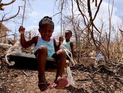 Tiquania Lewis, de dos años y su hermana Tiquanisha, de cinco, juegan cerca de unos árboles derribados por el huracán Irma en la isla de Anguilla, en el Caribe, en septiembre de 2017.