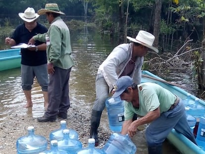 Voluntarios colocan garrafones de Segalmex en un bote para ser distribuidos en Macuspana (Estado de Tabasco) durante las inundaciones de 2020.