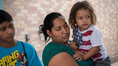 Una hondureña solicitante de asilo, sujeta a su hijo, con una camiseta de la bandera de Estados Unidos, en Texas.