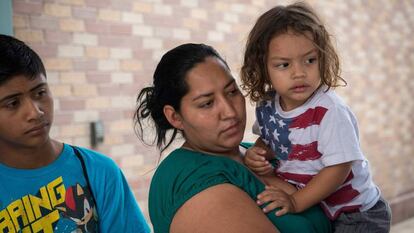 Una hondureña solicitante de asilo, sujeta a su hijo, con una camiseta de la bandera de Estados Unidos, en Texas.