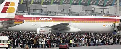 Cientos de pasajeros aguardan en las pistas del aeropuerto a ser evacuados en autobuses hacia la terminal 2.