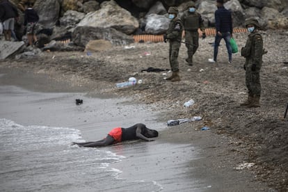 Um homem permanece deitado na praia enquanto o Exército isola a zona, nesta terça-feira.