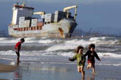 Varios niños corren en la playa de El Saler, en Valencia, en cuyas inmediaciones se encuentran varados los buques BSLE Sunrise y Celia a causa del temporal de la noche del viernes.