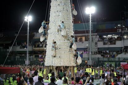 Los participantes escalan la torre de bollos durante la festividad de Bun.  