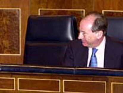 El ministro de Justicia, Ángel Acebes, y el vicepresidente y ministro de Economía, Rodrigo Rato, ayer, en el Congreso.