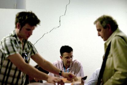 Votación en una mesa electoral instalada en la Casa de la Cultura de Lorca, con una grieta en la pared.