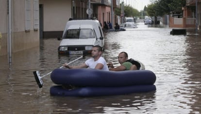 Dos hombres, en una barca hinchable, el pasado día 29 en una calle de Burriana, localidad que sufrió los efectos del temporal.