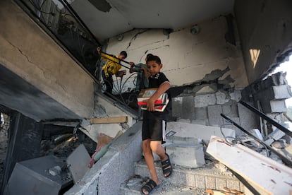 Niños palestinos sacaban este domingo libros religiosos de una mezquita destruida tras un ataque aéreo israelí en Jan Yunis.