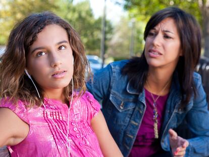 Una madre intenta hablar con su hija, mientras esta la ignora.