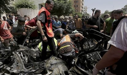 Palestinos inspeccionan los restos del vehículo del dirigente de Hamás Mohame Ghoul, alcanzado este domingo en un ataque contra Gaza.