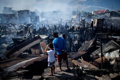 Dos residentes observan las casas destruidas por un incendio en Navotas, en la bahía de Manila (Filipinas), el 8 de noviembre.