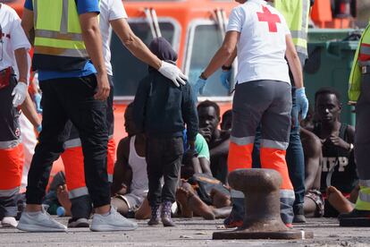 Dos miembros de Cruz Roja acompañan a un niño llegado en un cayuco a Tenerife en abril.