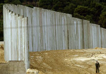 Un palestino camina junto al muro israelí ayer en el tramo que separa Jerusalén de Cisjordania.