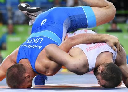 Magomed Idrisovitch Ibragimov (blanco), de Uzbekistán, lucha por el bronce contra Valerii Andriitsev, de Ucrania.