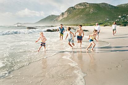 Una familia juega en la playa, en una foto de archivo. 