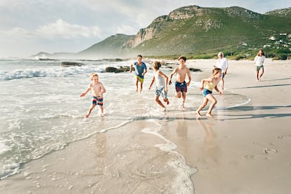 Una familia juega en la playa, en una foto de archivo.