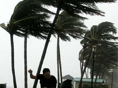 Dos hombres huyen de los fuertes vientos al paso del ciclón Katrina por Deerfield, en Florida.