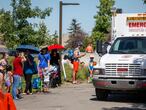 A Salvation Army EMS vehicle is setup as a cooling station as people lineup to get into a splash park while trying to beat the heat in Calgary, Alta., Tuesday, June 29, 2021. Environment Canada warns the torrid heat wave that has settled over much of Western Canada won't lift for days. THE CANADIAN PRESS/Jeff McIntosh
