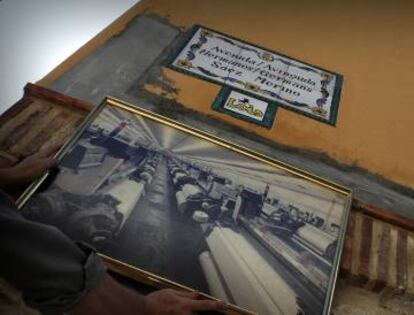 Placa de la avenida dedicada a los creadores de Lois en Millares y, debajo, foto de cómo era la antigua fábrica.