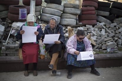 Unas mujeres leen un folleto distribuido por activistas pro rusos detrás de unas barricadas en Donetsk (Ucrania).