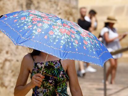 Un turista se protege del calor con un paraguas mientras pasea por las calles de la judería de Córdoba, el pasado sábado.