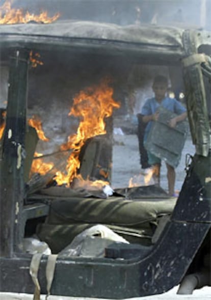 Vehículo estadounidense incendiado después de que sus ocupantes lo abandonaran tras ser atacado en Bagdad.