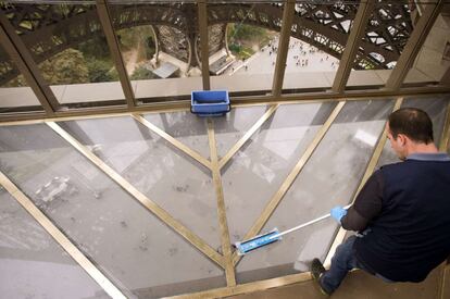 Un empleado limpia el suelo acristalado de la nueva planta de la Torre Eiffel, el 6 de octubre de 2014.