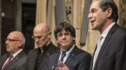 Carles Puigdemont, durante el acto, entre Ra&uuml;l Romeva (i) y el c&oacute;nsul Juan Alberto Buffa