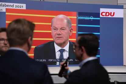 Militantes de la CDU siguen en la sede en Berlín el debate entre candidatos, con el socialdemócrata Olaf Scholz en pantalla.