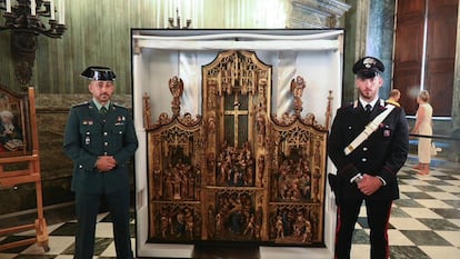 Un guardia civil y un 'carabinieri' custodian el retablo del siglo XVI recuperado en Italia tras ser sacado ilegalmente de España a finales de 2021, en una imagen facilitada por la UCO.
