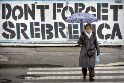 Una imagen de noviembre de 2017 en la que una mujer cruza una calle de Sarajevo (Bosnia) frente a un graffitti que reza: "no os olvidéis de Srebrenica".