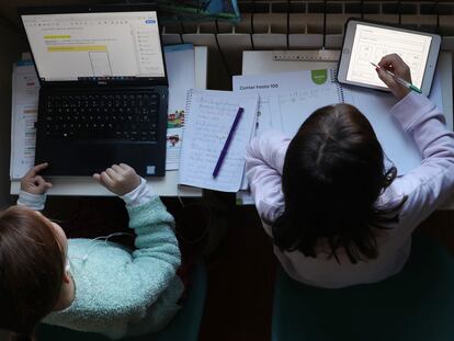 Dos niñas hacen los deberes del colegio en su casa durante a pandemia de coronavirus.