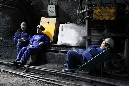 Uno de los mineros descansa en una carretilla.