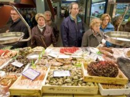Un grupo de personas hacen cola ante una pescadería. EFE/Archivo
