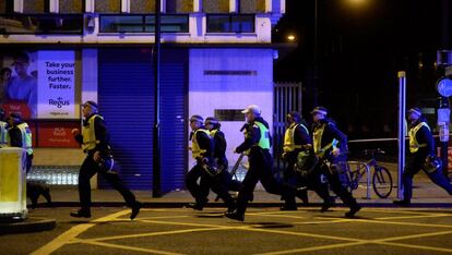 Un grupo de policías corre por las calles aledañas momentos después de producirse los atentados.