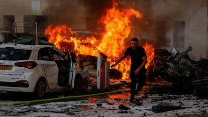 Un hombre huye de un incendio en la ciudad israelí de Ashkelón tras el lanzamiento de cohetes desde Gaza, este sábado.